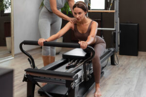People in pilates reformer class exercising their bodies